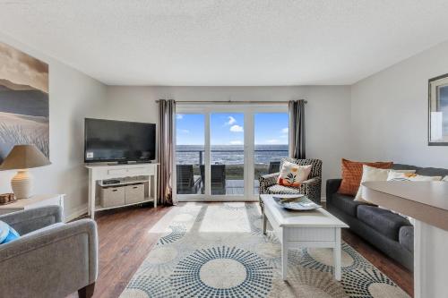 Winds II في كارولينا بيتش: غرفة معيشة مع أريكة وتلفزيون