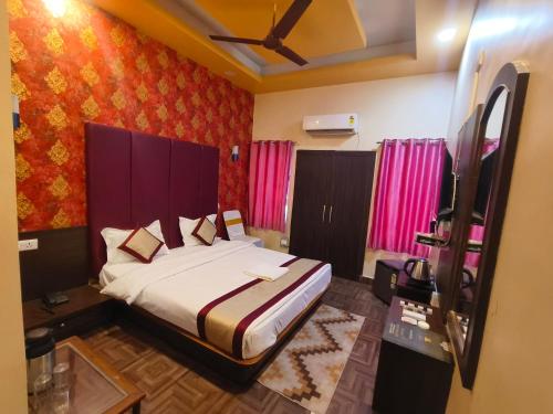 a bedroom with a bed and pink walls at Hotel The Siwan International in Siwān