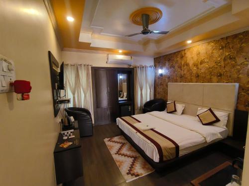 a hotel room with a bed and a desk and a room at Hotel The Siwan International in Siwān