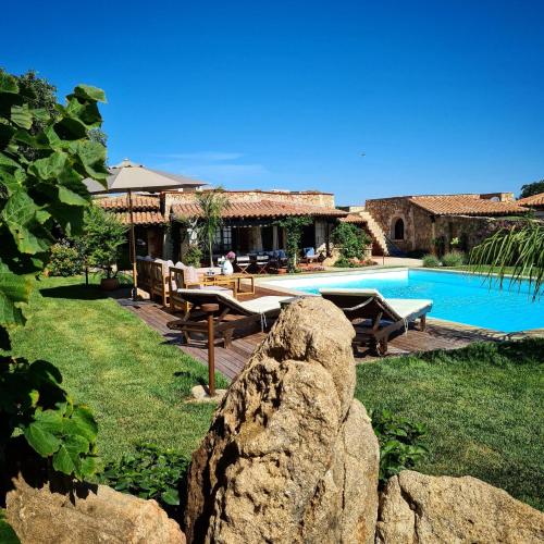 a resort with a swimming pool and a house at Villa Silnis -Puntaldia in Puntaldia