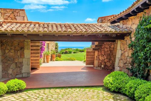 an entrance to a house with a stone wall at Villa Silnis -Puntaldia in Puntaldia