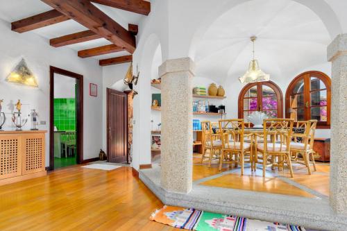 a kitchen and dining room with a table and chairs at Villa Silnis -Puntaldia in Puntaldia