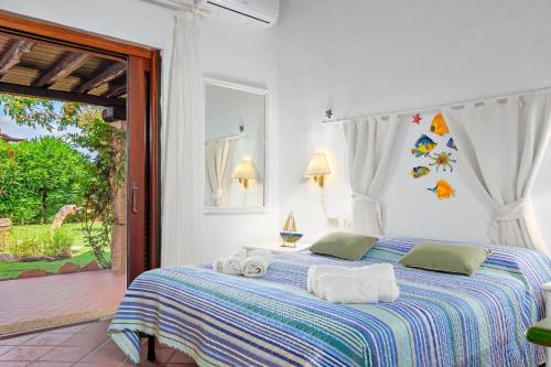 a bedroom with a bed with towels on it at Villa Silnis -Puntaldia in Puntaldia