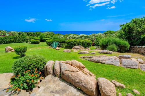 a garden with rocks and flowers on the grass at Villa Silnis -Puntaldia in Puntaldia