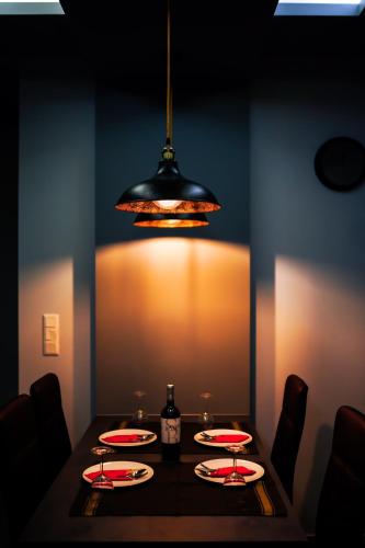 a dining room with a table with plates and a light at P & K Design LTD Flats in Nea Moudania