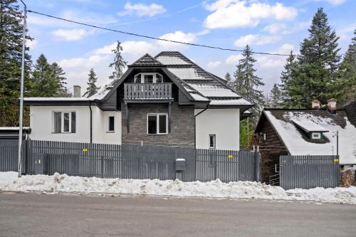 a house with a fence in front of it at SEVEN Apartments in Predeal