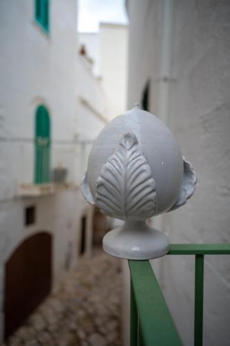 a white mushroom figurine sitting on a railing at La Piccola Suite in Fasano