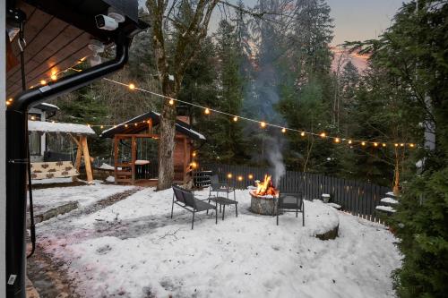 a fire pit in a yard with snow and lights at SEVEN Apartments in Predeal