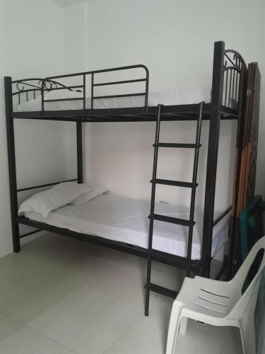 a black bunk bed with a ladder next to a chair at Hadiqah event venue in Mangangpico