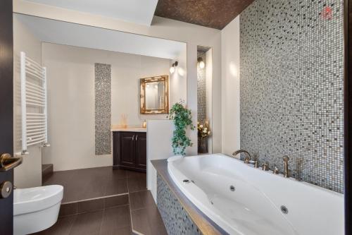 a bathroom with a tub and a toilet and a sink at Luca Residence Beautiful Villa in Trăisteni