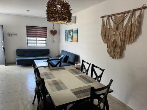 a dining room and living room with a table and chairs at La Casa del Arbol -4bed 3 bath in Puerto Morelos