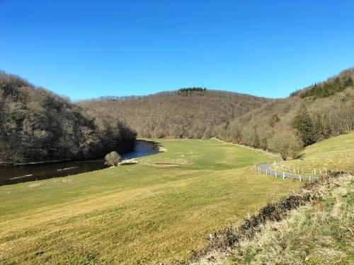 a view of a river in a field with trees at Au Pied Du Château in Bouillon