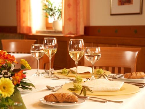 a table with wine glasses and food on it at Landhotel Bärnriegel in Mauth