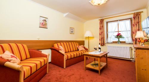 a living room with two couches and a table at Landhotel Bärnriegel in Mauth