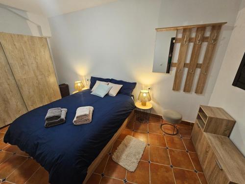 Un dormitorio con una cama azul con toallas. en Ohanes tu descanso, en Ohanes