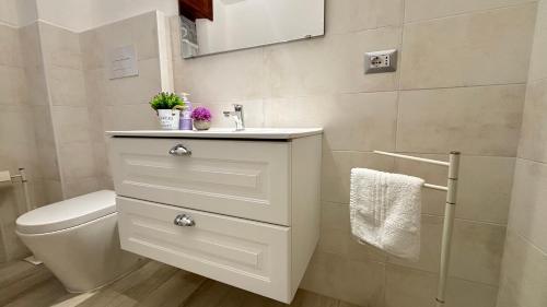 a white bathroom with a sink and a toilet at A Casa di Nonno tra mare e montagna AC WiFi in Dorgali