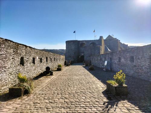 a cobblestone alley with a castle in the background at La seigneurie de Godefroy in Bouillon