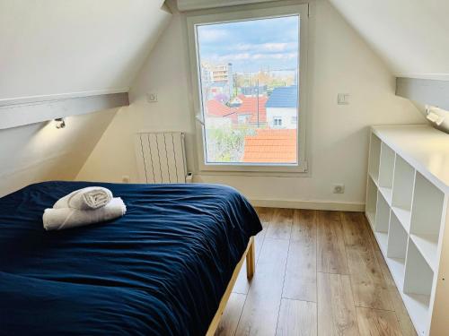 une chambre avec un lit et une grande fenêtre dans l'établissement Cosy Maison aux portes de paris, à Colombes