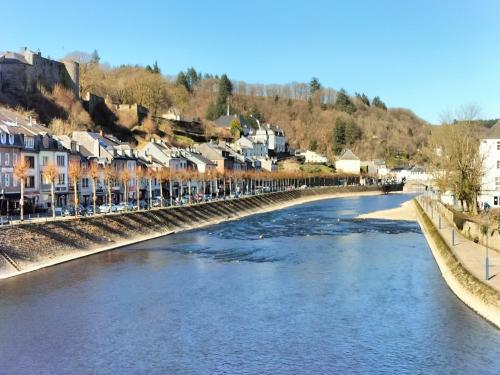a bridge over a river with houses and condos at L'alcôve de Ide in Bouillon