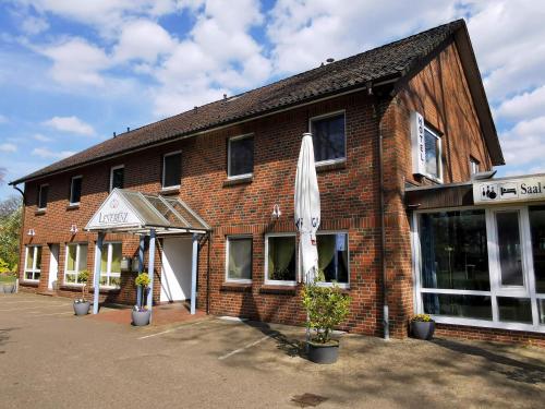 a brick building with an umbrella outside of it at Landgasthof Leverenz "Traditionell & rustikal" in Neuenkirchen