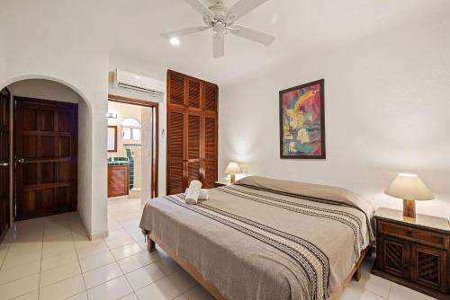 a bedroom with a bed and a ceiling fan at Del Sol Beachfront in Akumal