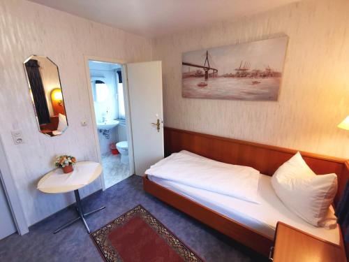 a small bedroom with a bed and a bathroom at Landgasthof Leverenz "Traditionell & rustikal" in Neuenkirchen