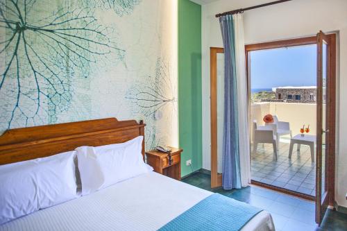 a bedroom with a bed and a balcony with a table at Pantelleria Resort in Pantelleria
