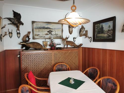 a dining room with a table and cats on the wall at Landgasthof Leverenz "Traditionell & rustikal" in Neuenkirchen