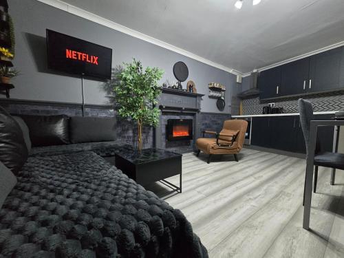 a bedroom with a bed and a living room with a fireplace at Cozy Flat London with private entrance in London