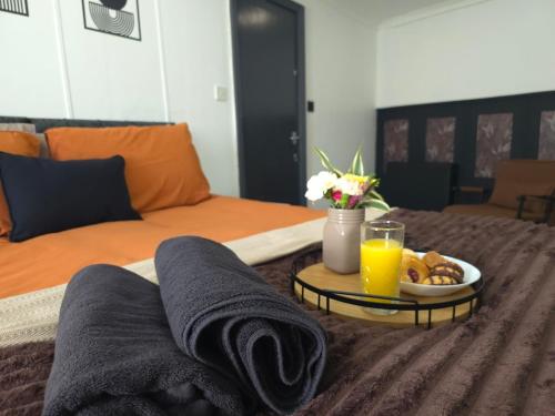 a bed with a tray of food and two glasses of orange juice at Cozy Flat London with private entrance in London
