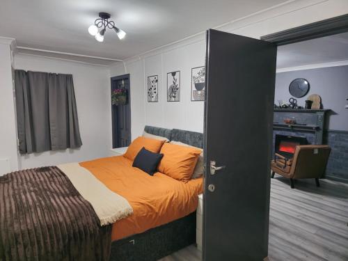 a bedroom with a bed with an orange bedspread at Cozy Flat London with private entrance in London