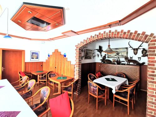 a restaurant with tables and chairs and a brick wall at Landgasthof Leverenz "Traditionell & rustikal" in Neuenkirchen