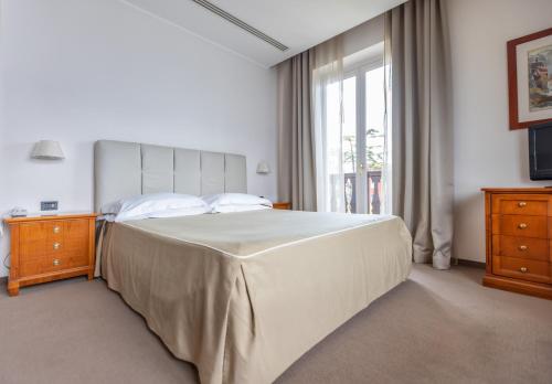 a bedroom with a large bed and a window at Bellevue San Lorenzo (Adults Only) in Malcesine