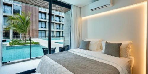 a bedroom with a large bed and a swimming pool at Porto Alto Resort in Porto De Galinhas