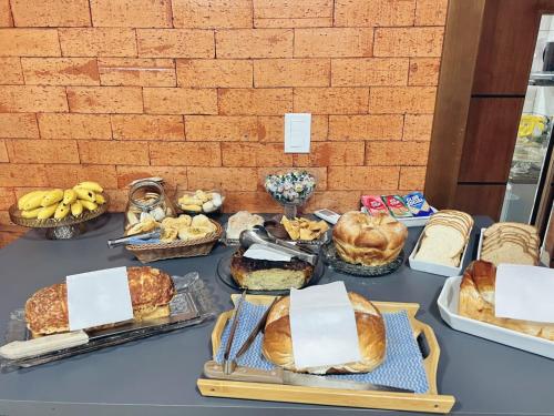 a table topped with lots of different types of bread at Hotel Amazonas in Cacoal