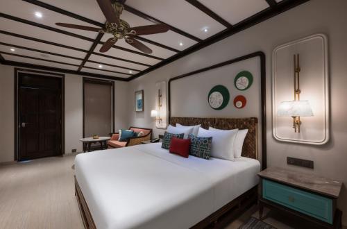 a bedroom with a large white bed with a ceiling fan at Fountain, Mahabaleshwar - IHCL SeleQtions in Mahabaleshwar