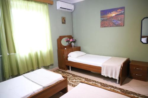 a bedroom with two twin beds and a window at Valley View Home Drobonik in Drobonik