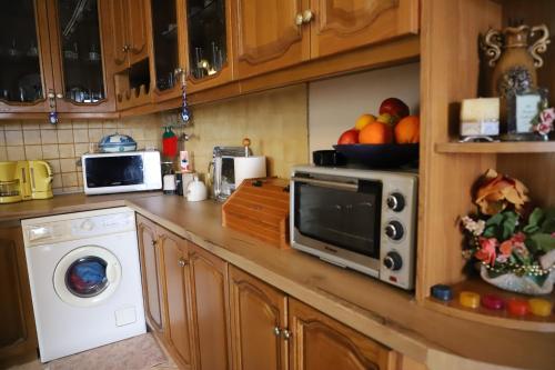 a kitchen with a microwave and a washing machine at Valley View Home Drobonik in Drobonik