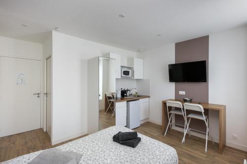 une chambre avec un lit et une cuisine avec une table dans l'établissement Cidre, à Brest