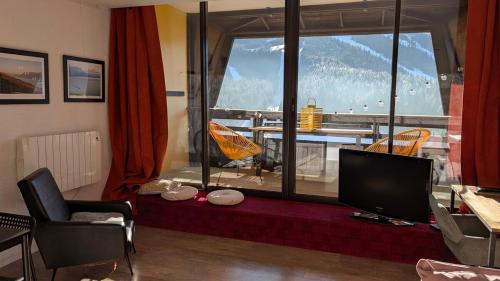 un salon avec une grande fenêtre avec vue dans l'établissement Large studio artist residence - Splendid view, à Villard-de-Lans