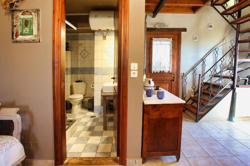 a bathroom with a sink and a toilet and a staircase at Venetis Luxury Apartments in Chios