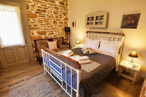 a bedroom with a bed and a stone wall at Venetis Luxury Apartments in Chios