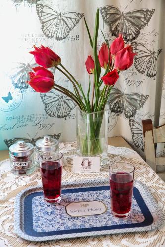 a table with a vase of red flowers on it at Venetis Luxury Apartments in Chios