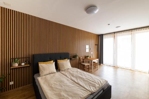 a bedroom with a large bed and a table at VOUSATÁ DÁMA - PS3 - Parking free in Prague