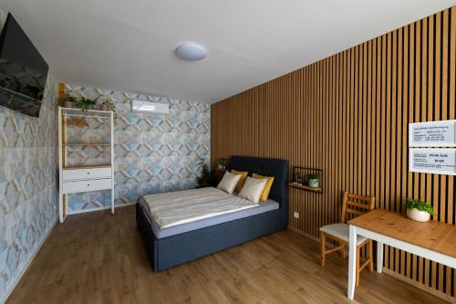 a small bedroom with a bed and a table at VOUSATÁ DÁMA - PS3 - Parking free in Prague