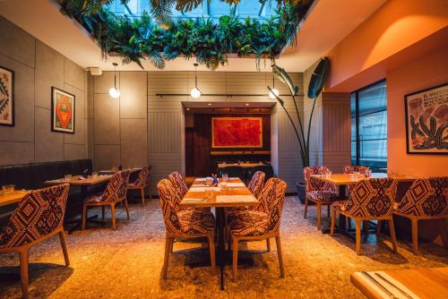 a restaurant with tables and chairs in a room at Euston Square Hotel in London