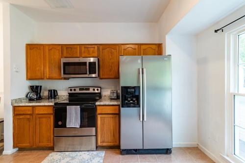 a kitchen with wooden cabinets and a stainless steel refrigerator at Refreshing and Restful Stay in Montgomery Village