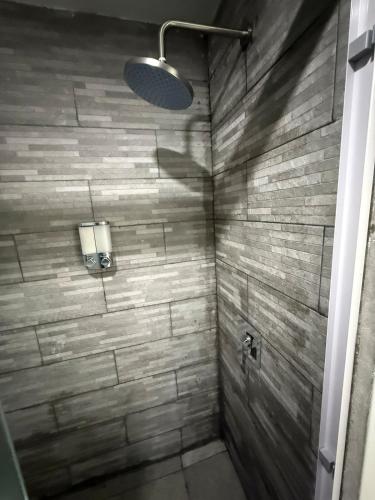 a bathroom with a shower with a stone wall at Departamento nuevo con Vista al Mar! in Acapulco