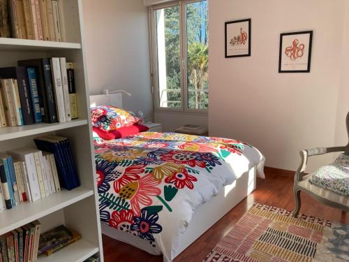 - une chambre avec un lit et une étagère avec des livres dans l'établissement Appartement Pontivy, à Pontivy