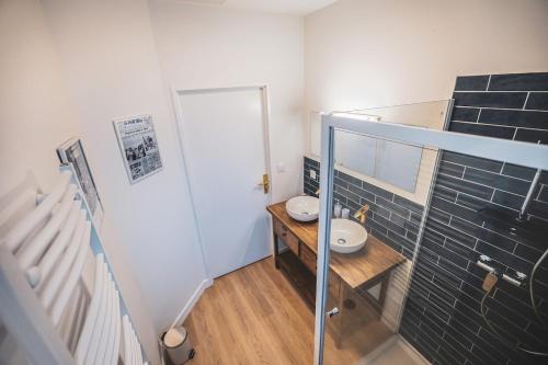 une salle de bain avec un lavabo sur une table en bois dans l'établissement L'Héritage Agenais Coeur du centre ville, à Agen